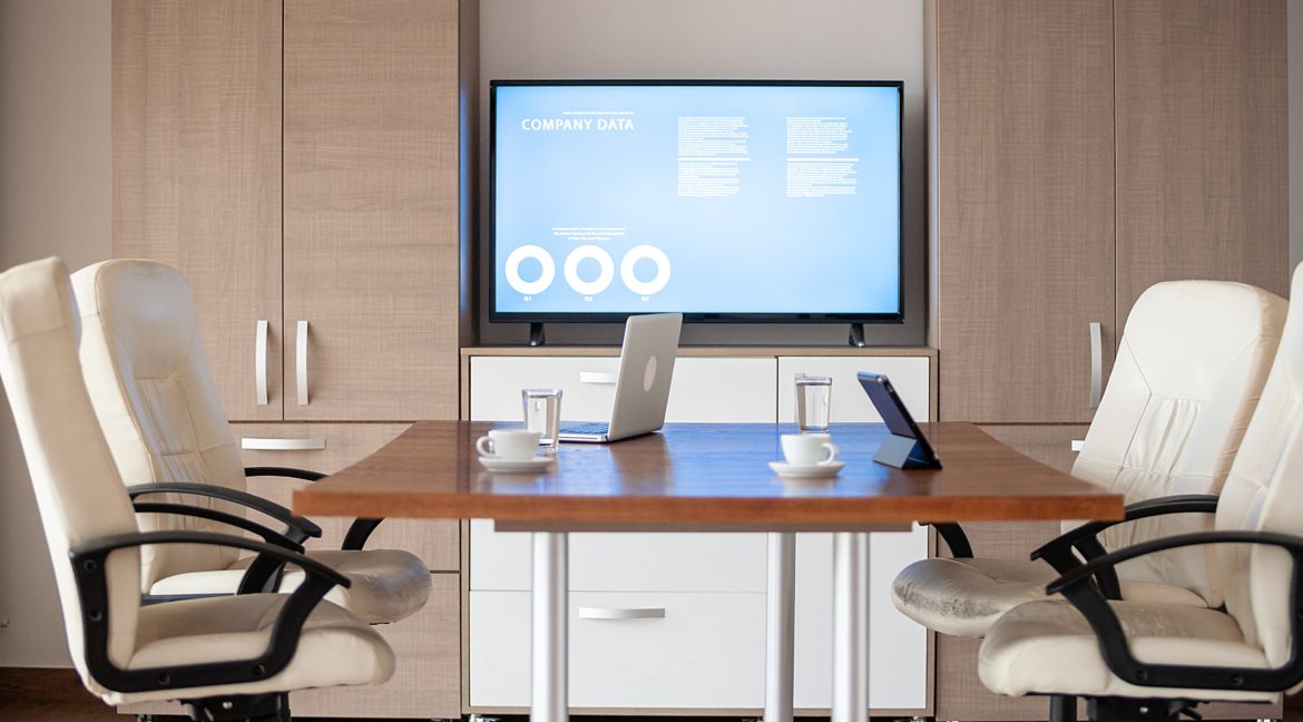 Empty business meeting conference room with graphs and diagrams on TV